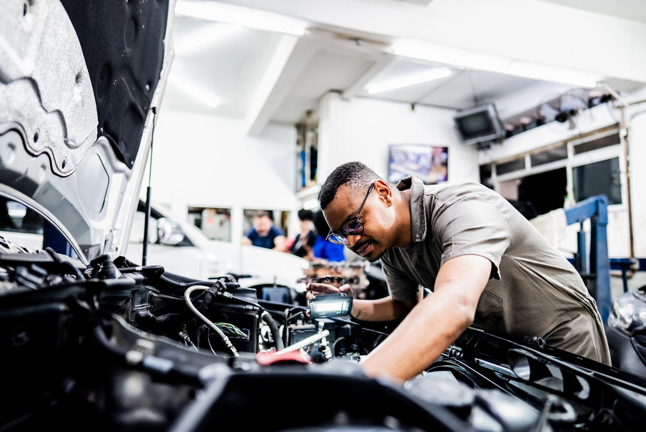 Automotive technician inspecting an engine